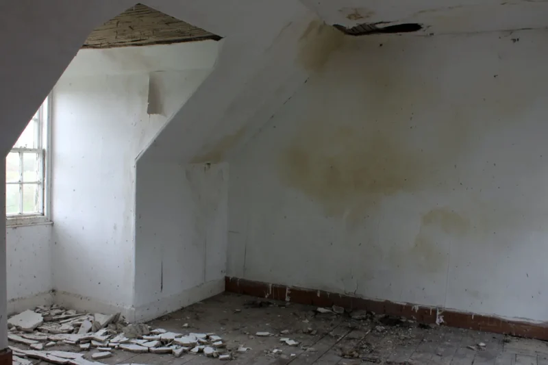 Wide interior view of abandoned cottage window with fallen plaster