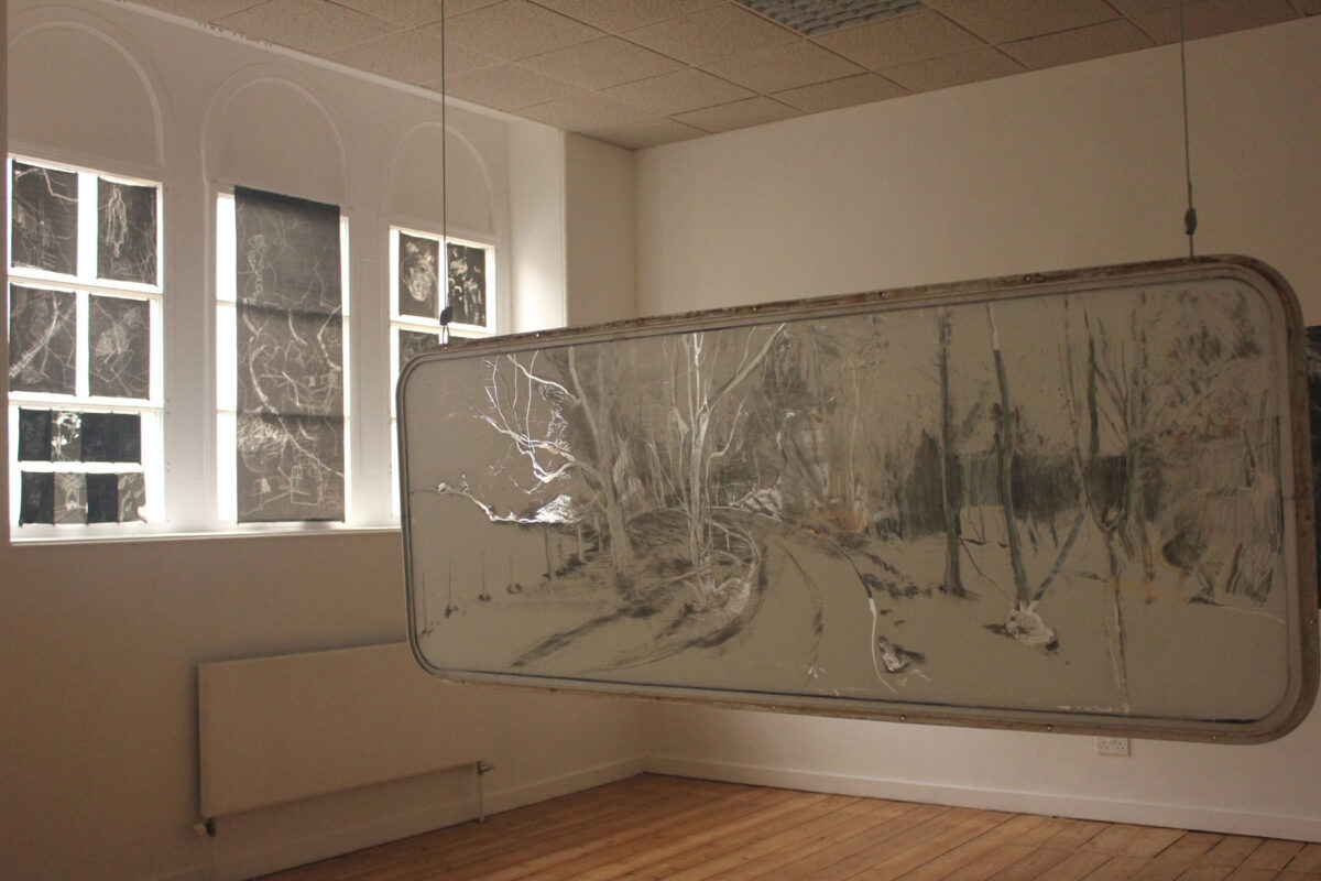 Gallery view of sgraffito drawing on caravan window with carbon paper drawings in gallery windows